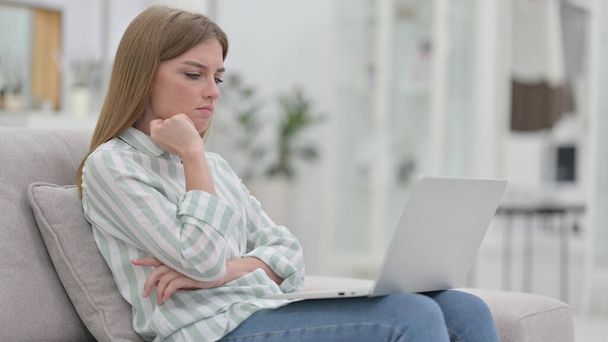 家庭でノートパソコンを考えて働く若い女性  - 写真・画像