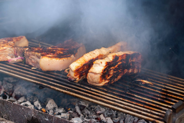 grilling steaks on flaming grill. shot with selective focus. - Foto, Imagem