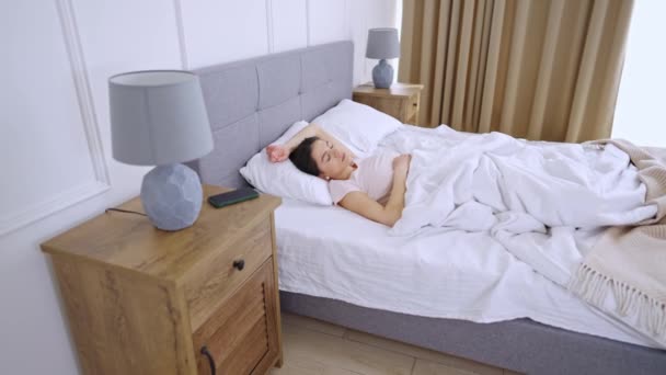 Mujer joven duerme en una cama cómoda - Metraje, vídeo