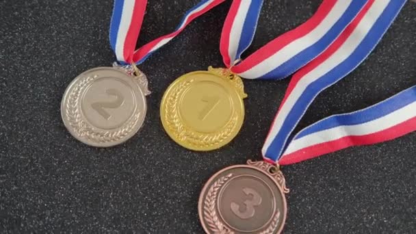 Ezüst, arany, bronz sportérmek bajnokok szalagjaival. - Felvétel, videó