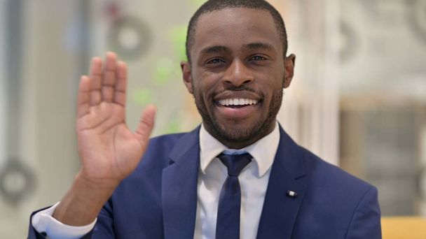 Portrait of Cheerful African Businessman Waving at the Camera  - Photo, Image