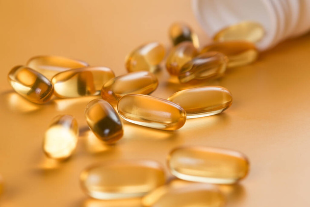 Veel capsules Omega 3 op gele achtergrond. Close-up, product met hoge resolutie. Gezondheidszorgconcept. - Foto, afbeelding