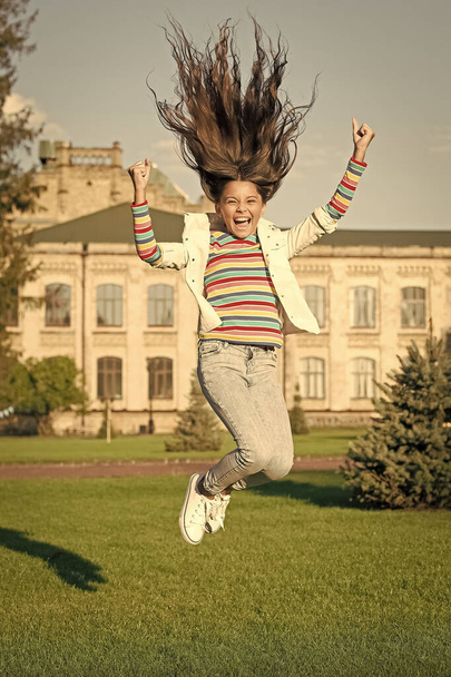 full of energy. childhood happiness. small girl with curly hair jump outdoor. spring holiday celebration. child fly in motion. activity for kids. happy kid jumping and feel free - Foto, afbeelding