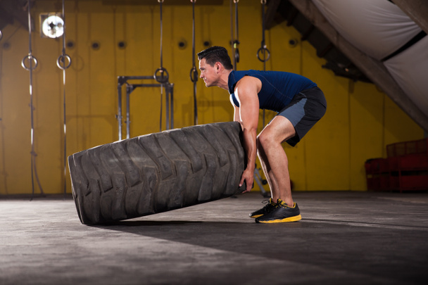 Flipping un pneu dans une salle de gym
 - Photo, image