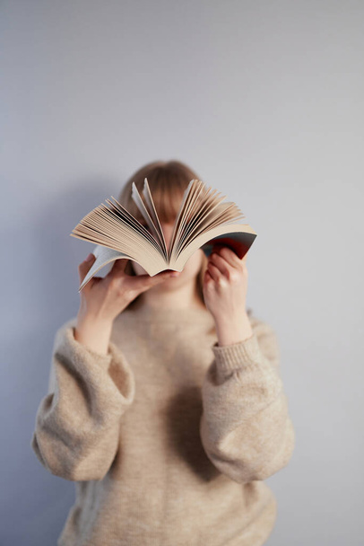 Young girl leafing through an open book. Knowledge concept - 写真・画像