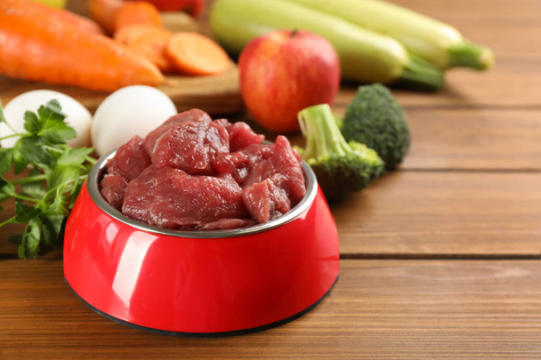 Raw meat and fresh ingredients on wooden table, closeup. Natural pet food - Foto, immagini