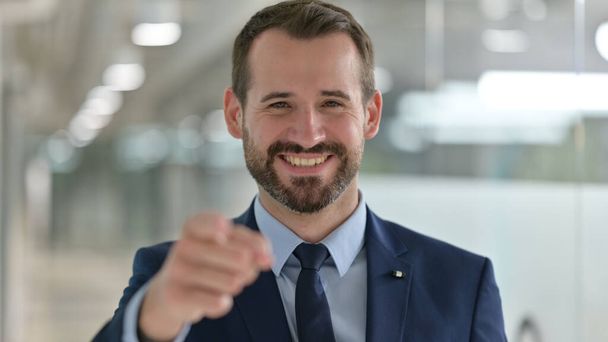 Porträt eines glücklichen Geschäftsmannes mittleren Alters mit Fingerzeig  - Foto, Bild