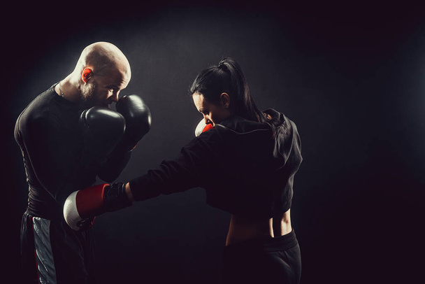 Woman exercising with trainer at boxing and self defense lesson - Photo, Image
