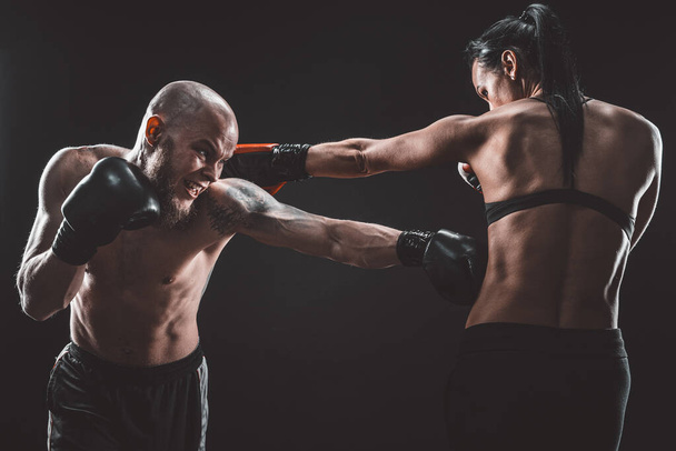 Shirtless Woman exercising with trainer at boxing and self defen - Photo, image