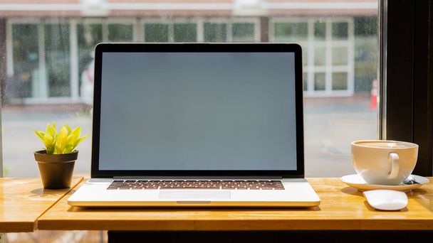 Ноутбук, который сидит на столе с кофейной кружкой - Фото, изображение
