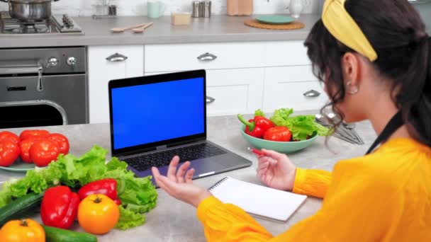 Blue screen laptop: Woman watch online cooking course webinar tells teacher chef - Кадры, видео