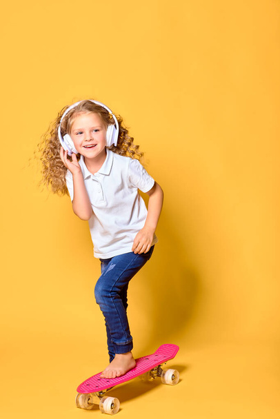 Active and happy girl with curly hair, headphones having fun wit - Zdjęcie, obraz