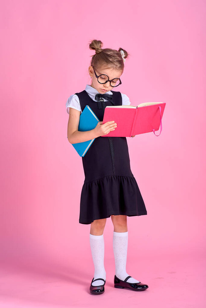 Cute little girl with glasses and books on pink background, spac - Foto, Bild