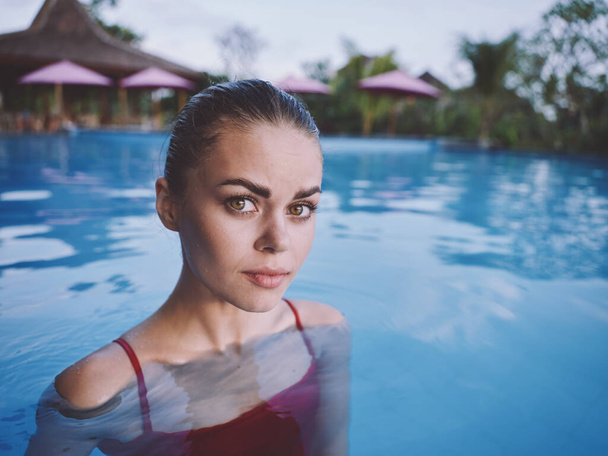 attrayant femme nager dans la piscine dans un maillot de bain rouge portrait en gros plan - Photo, image