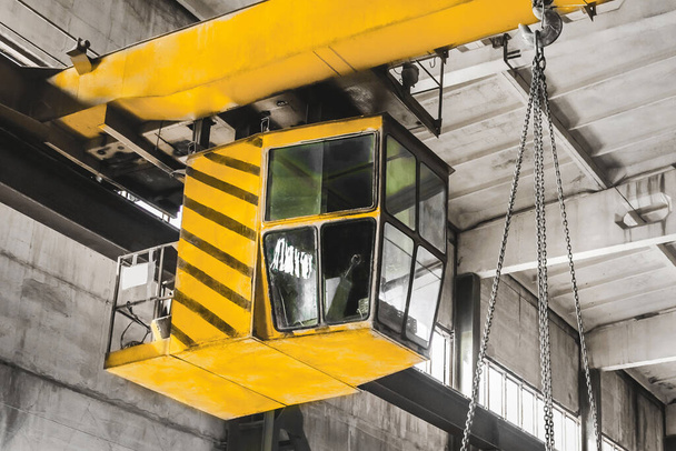 L'équipement de levage de grue aérienne dans une usine industrielle transporte un rail de fer sur la chaîne de levage. - Photo, image