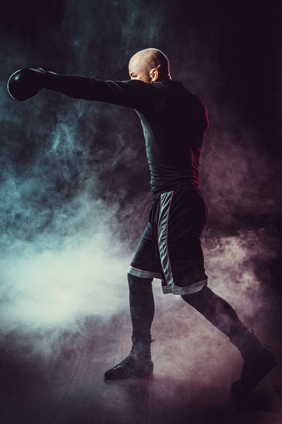 Sportsman boxer fighting on black background with smoke. Boxing - Photo, Image