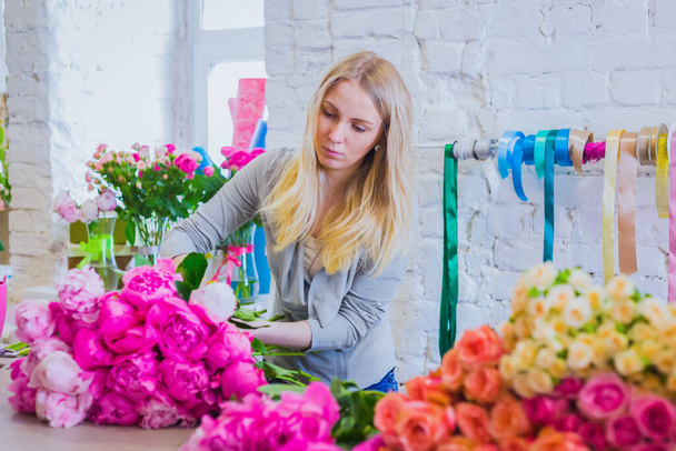 Florista profesional haciendo hermoso ramo de peonía en la tienda de flores - Foto, Imagen