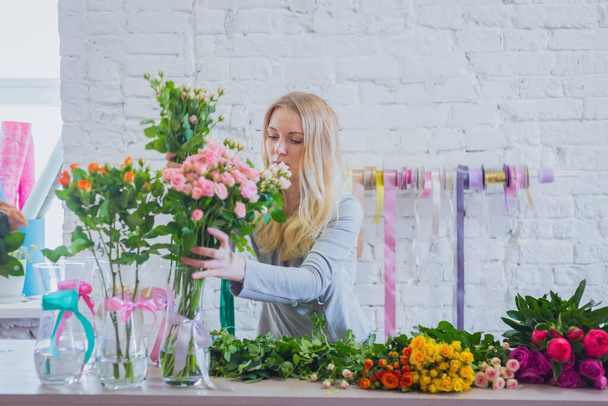 Πορτρέτο του επαγγελματία ανθοπώλη που εργάζεται με λουλούδια στο στούντιο - Φωτογραφία, εικόνα