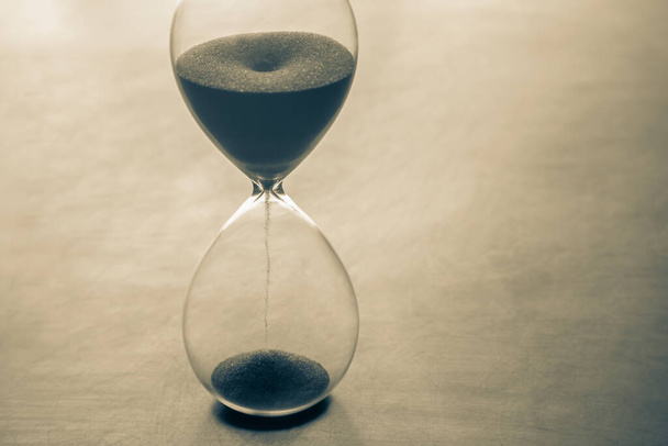 Hourglass on a dark background. Time is money. Business solutions in time. - Zdjęcie, obraz