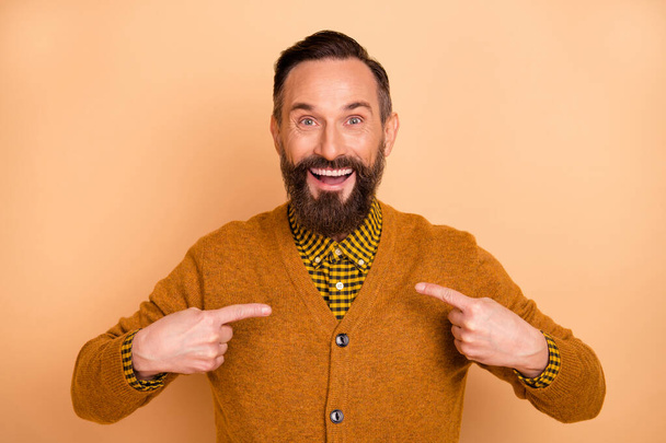 Photo of handsome excited man indicate forefingers himself open mouth wear cardigan isolated beige background - 写真・画像