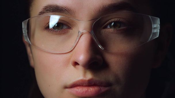 Portrait du visage d'une femme d'affaires réfléchie déplaçant les yeux à travers des lunettes intelligentes.  - Photo, image