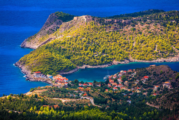 Turquoise colored bay in Mediterranean sea with beautiful colorful houses in Assos village in Kefalonia, Greece. Town of Assos with colorful houses on the mediterranean sea, Greece.  - Photo, Image