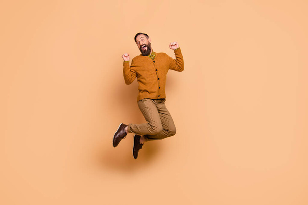 Full body portrait of astonished man fists up open mouth celebrate isolated on beige color background - Фото, зображення