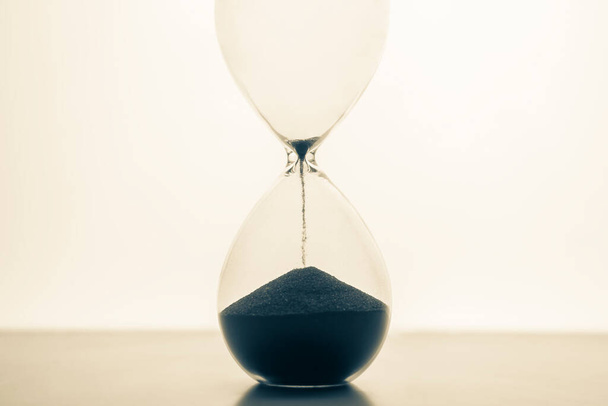 Hourglass on a light background. Time is money. Business solutions in time. - Foto, Bild