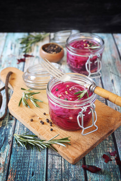Pickled red onion salad in two jars, spices and rosemary  - Foto, immagini