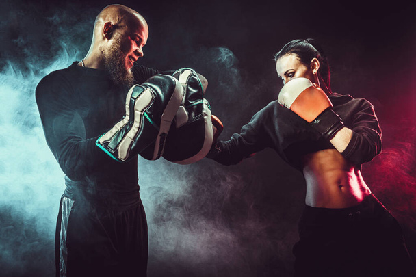 Woman exercising with trainer at boxing and self defense lesson - Fotografie, Obrázek