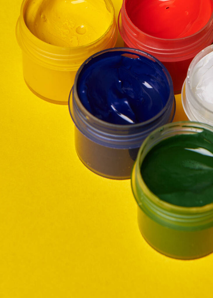 multicolored cans of paint on a yellow background - Photo, Image