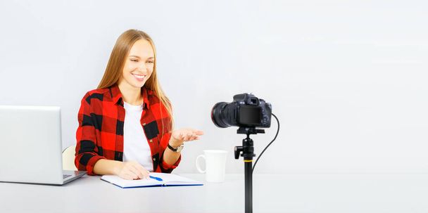 Attractive young woman blogger is recording on the camera at home. Online learning concept. Banner. - Fotó, kép