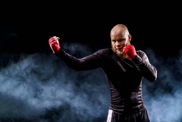 Sportsman boxer fighting on black background with smoke. Boxing - Фото, зображення