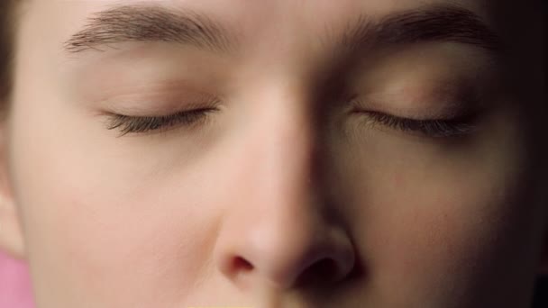 Nahaufnahme schönes weibliches Gesicht mit geschlossenen Augen. Ernsthafte junge Frau  - Filmmaterial, Video