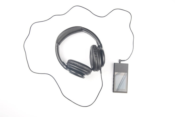 Наушники для прослушивания музыки с цифровым аудиоплеером на белом фоне - Фото, изображение