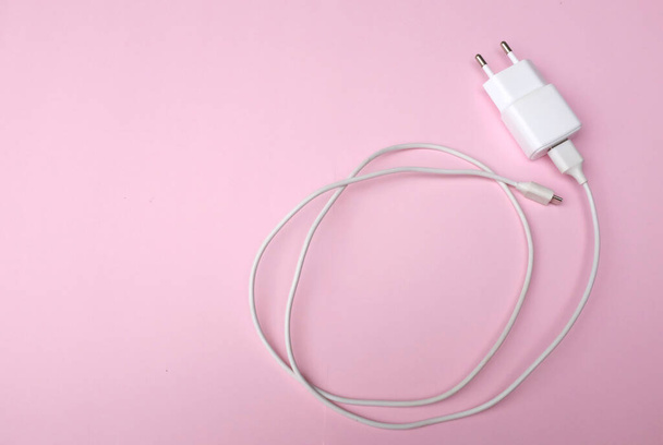 Charger Adapter of smartphone color white on pink pastel Background - Foto, Imagen