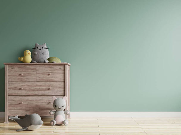 Das Kinderzimmer mit grüner Wand ist leer. Dekoriert mit Puppen auf Holzschränken mit Holzböden. - Foto, Bild
