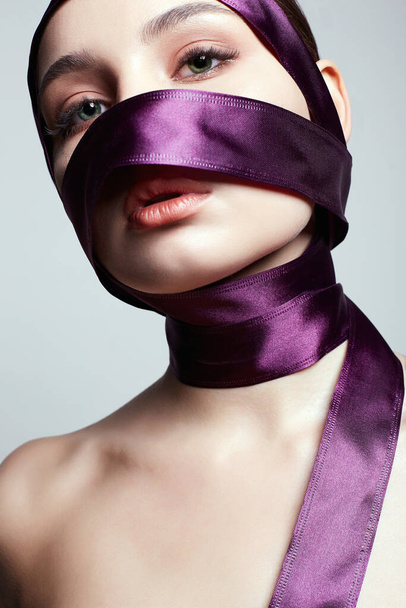 beautiful young woman in silk ribbon on her face and body. beauty portrait of pretty Girl - Foto, Imagen