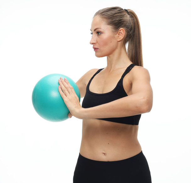 Young fit adult woman doing yoga exercise workout with gymnastics ball. - Photo, Image