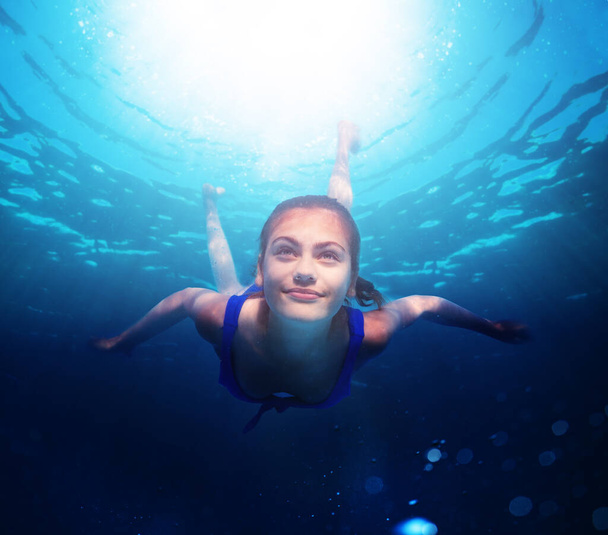 Kızın portresi su altında yüzüyor kendinden emin pozitif bir gülümsemeyle denizin derinliklerinde - Fotoğraf, Görsel