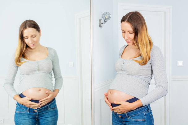 Pregnant nine month woman and reflection in the mirror at home - Φωτογραφία, εικόνα
