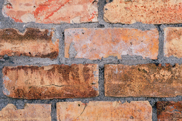 A closeup shot of an old weathered brick wall - Fotó, kép