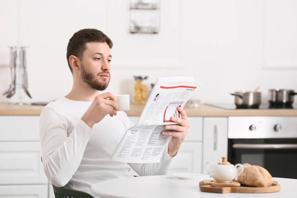 Komea mies lukee sanomalehteä keittiössä - Valokuva, kuva