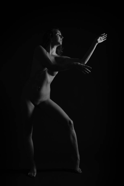 A nude sexy Caucasian woman posing isolated on black background - 写真・画像