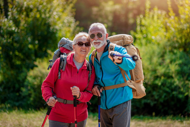 Senior couple with backpacks on hiking have fun in nature. Love, people,nature and lifestyle concept. - Photo, Image