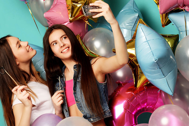 Two girls friends with colorfoul balloons make selfie on a ph - Φωτογραφία, εικόνα