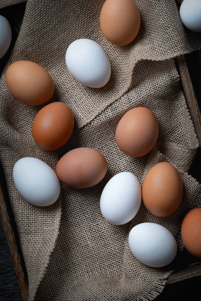 Νωπά αυγά σε κουτί σε παλιό ξύλινο τραπέζι. - Φωτογραφία, εικόνα