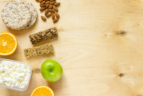 Flat lay of various healthy snacks on wooden background, space for text - Foto, immagini