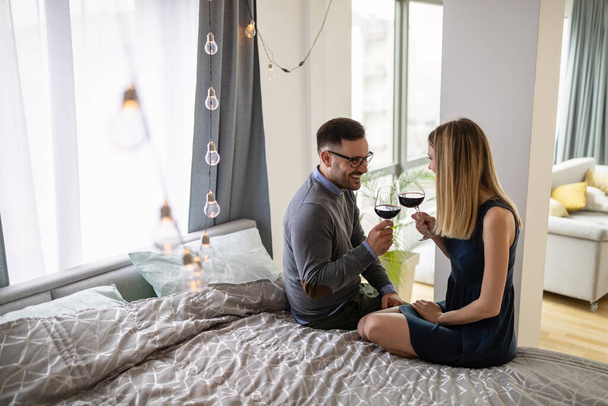 Happy couple in love drinking wine and having romantic date - Фото, зображення