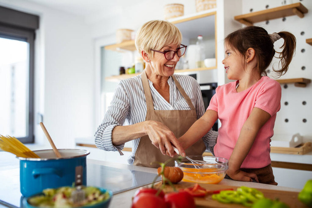 Family fun love generation concept. Grandmother and granddaughter are cooking on kitchen. - Foto, Imagen